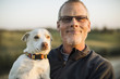 © Eric Raptosh Photography/Blend Images - Caucasian man holding dog outdoors
