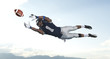 © Pete Saloutos/Blend Images - African American football player catching ball