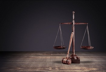 Wall Mural - Lawyer. Law scales on table in front black background. Symbol of