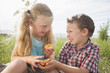 © Mike Kemp/Blend Images - Caucasian children sharing fruit outdoors
