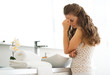 © Alliance - Frustrated young woman standing in bathroom