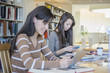 © John Fedele/Blend Images - Students working at desk in library