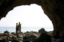 Couple Standing In Rocky Beach Cave
