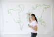 © JGI/Blend Images - Mixed Race woman painting world map