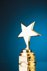 Wall Mural - gold star trophy against blue background