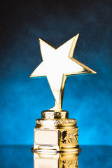Wall Mural - gold star trophy against blue particles background