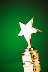 Wall Mural - gold star trophy against green background