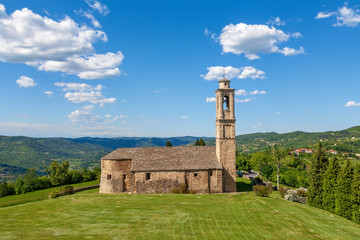 Wall Mural - Old church on green lawn in Italy.