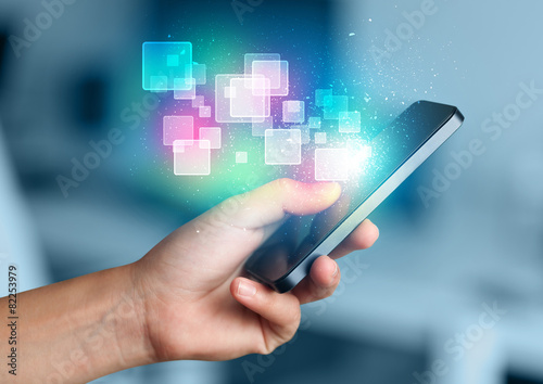 Fotografie, Obraz Hand holding smart phone with abstract glowing squares