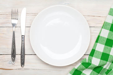 Poster - Empty plate, silverware and towel over wooden table background