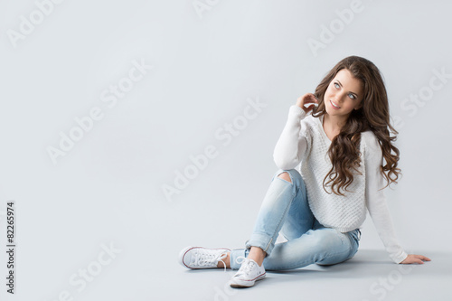 Fotografía Cute woman sitting on the floor and smiling