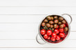 Cherry tomatoes in rustic colander on white wooden table