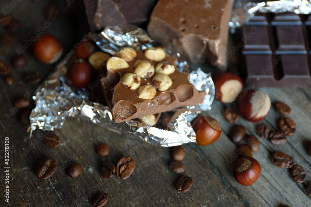 Set of chocolate with nuts on wooden table, closeup
