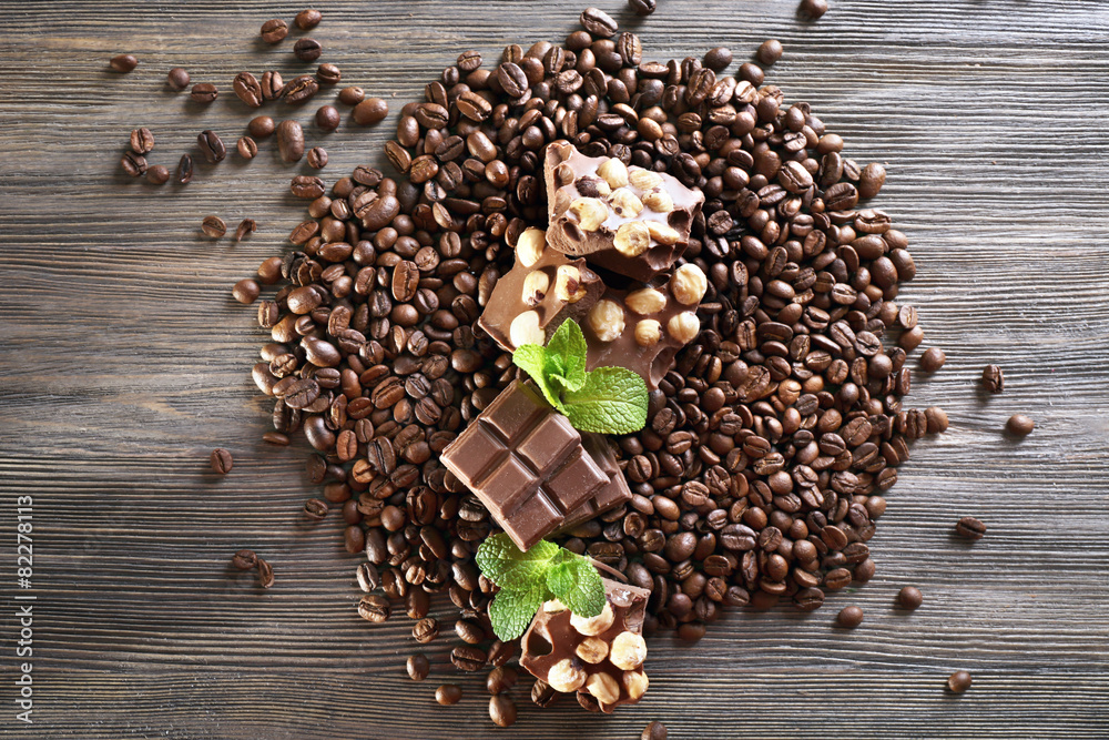 Chocolate with mint and coffee beans on wooden table, closeup