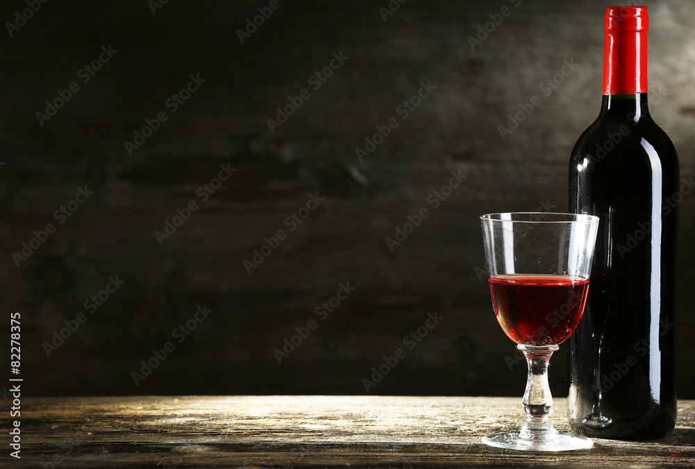 Wineglass and bottle on wooden background