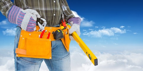 Poster - Composite image of handyman holding spirit level