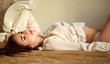© okostia - Sensual young woman lying in bed and looking thoughtfully