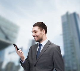 Wall Mural - young smiling businessman with smartphone