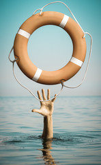 Wall Mural - Hand in sea water with lifebuoy asking for help