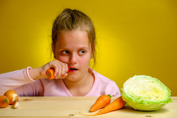 Little girl doesn't like to eat healthy carrot