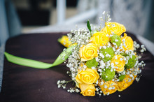 Fresh Yellow Roses With A Checkered Ribbon On Wooden Table