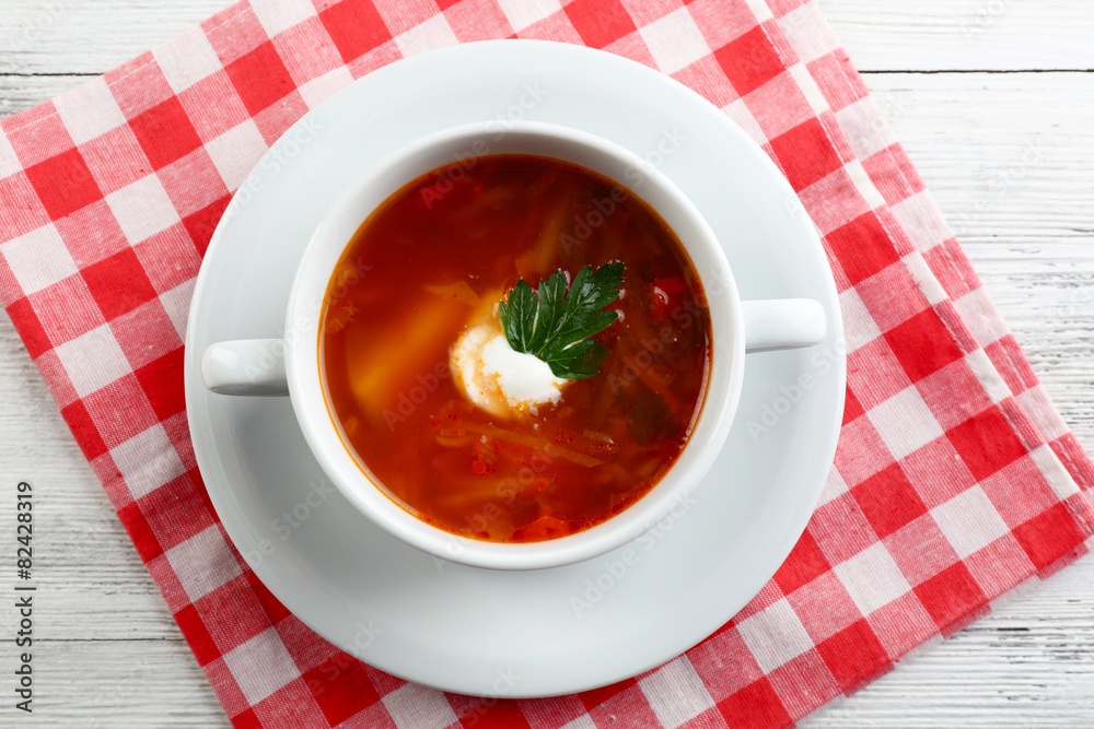 Ukrainian beetroot soup - borscht, on napkin, on wooden background