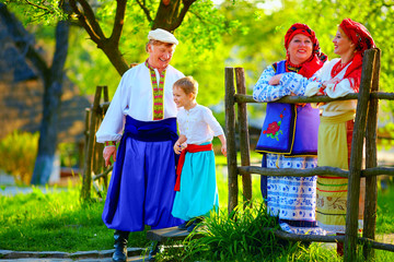 happy ukrainian family in traditional costumes talking outdoor