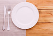 © missty - Empty plates, cutlery tablecloth on wooden table for dinner,