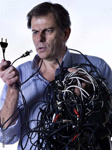 Fotografie, Obraz Man tangled in power cables, looking puzzled
