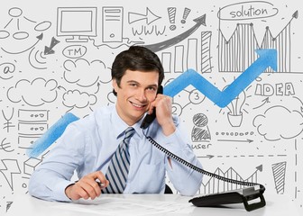 Canvas Print - Telephone. Happy businessman on phone while using computer in