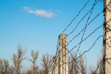 post with barbed wire against the sky