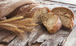 Fresh bread and wheat on the old wooden background. Toned