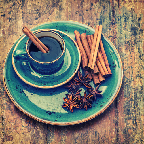 Fototapeta na wymiar Cup of black coffee with cinnamon and star anise spices