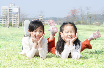 Cute happy children laying on grass outdoor