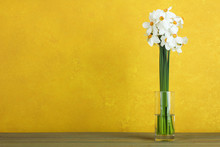 Daffodils In A Glass Vase On A Wooden Background