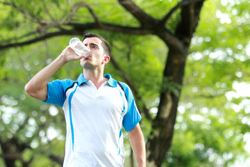 young sporty man drinking mineral water