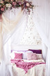 © Anastasiia Krivenok - White cozy bed with vintage pillow and flowers
