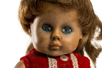 Close-up of an used doll in front of a white background