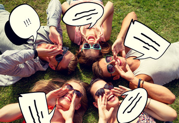 Canvas Print - group of smiling friends lying on grass outdoors