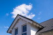 Haus mit Spitzdach mit blauen Himmel und Wolke