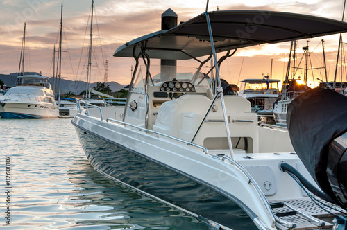 Fotografia Small motorboat docking at the marina at sunset time