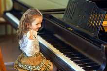Cute Little Girl Playing Grand Piano In Music School