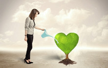 Business Woman Watering Heart Shaped Green Tree