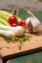 Two heads of spring onion on chopping board