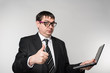 © kostyha - businessman holding a laptop, thumb to the top