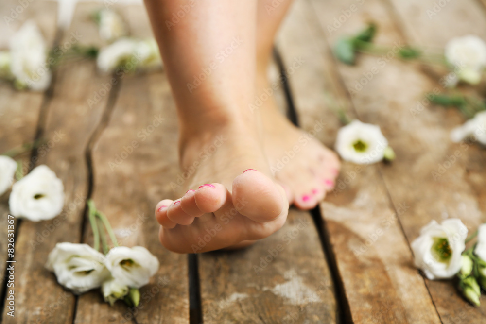Beautiful female legs on rustic wooden floor background
