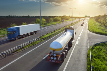 Two trucks on the highway at sunset in motion