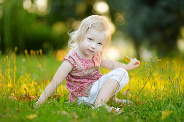 cute little girl toddler sitting on the grass