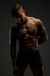 © Fxquadro - Muscular man with tattooes in deep shadows