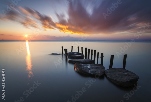 Naklejka na szybę Sea beach and breakwater at sunset